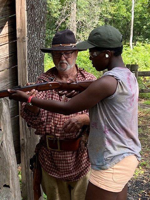 A Recipient of a Campership is Instructed on Gun Use at Camp