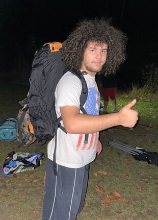 A Camping Essentials Recipient Poses with his New Backpack